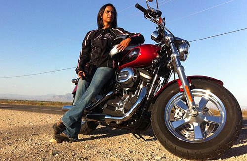 woman leaning on red harley davidson