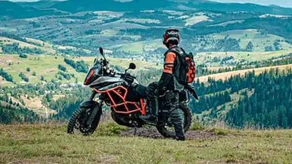 offroad biker sitting on ktm motorbike on mountain pass